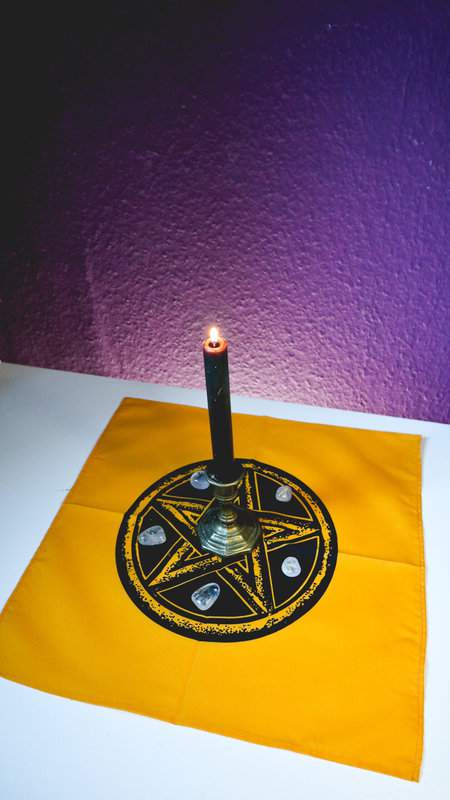 Altartuch in Gelb mit schwarzem Pentagrammaufdruck mit brennender Kerze und Runen als Deko