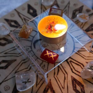 Brennende Teekerze Lichtblick für Zuversicht und positive Energie mit Glasrunen auf Holzboard
