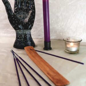Räucherstäbchen Protection im Holzhalter mit violetter Kerze Teelicht und schwarzer Handstatue als Deko