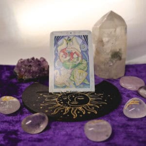 Kartenhalter mit goldener Sonne und Tarotkarte umrahmt von Glasrunen mit Amethystdrüse und Bergkristallspitze als Deko