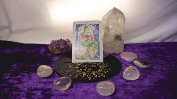 Kartenhalter mit goldener Sonne und Tarotkarte umrahmt von Glasrunen mit Amethystdrüse und Bergkristallspitze als Deko