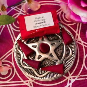 Räucherkegel Romantik auf Pentagram Räucherkegelhalter auf rotem Altartuch mit Kirschblüten und Rosen als Deko